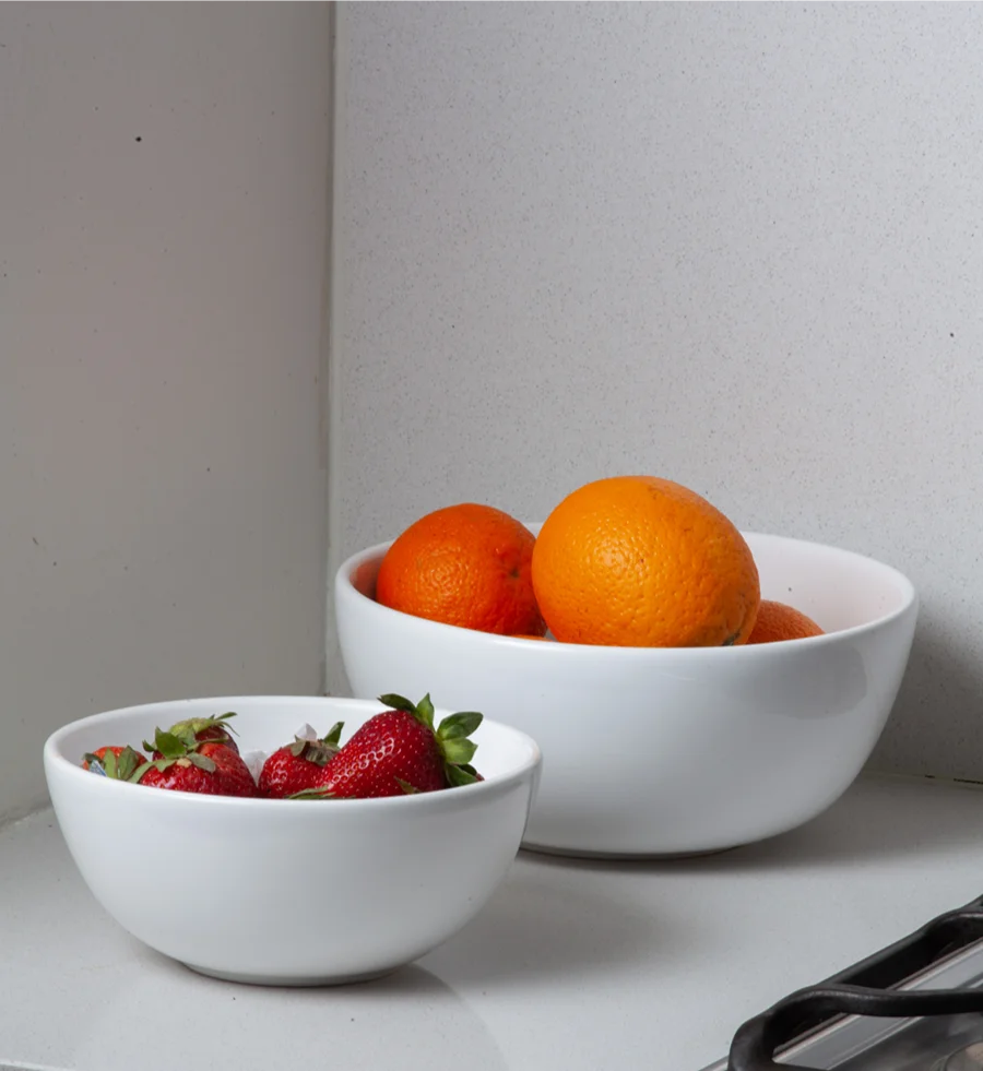 Bowls de cerámica blancos con naranjas y frutillas