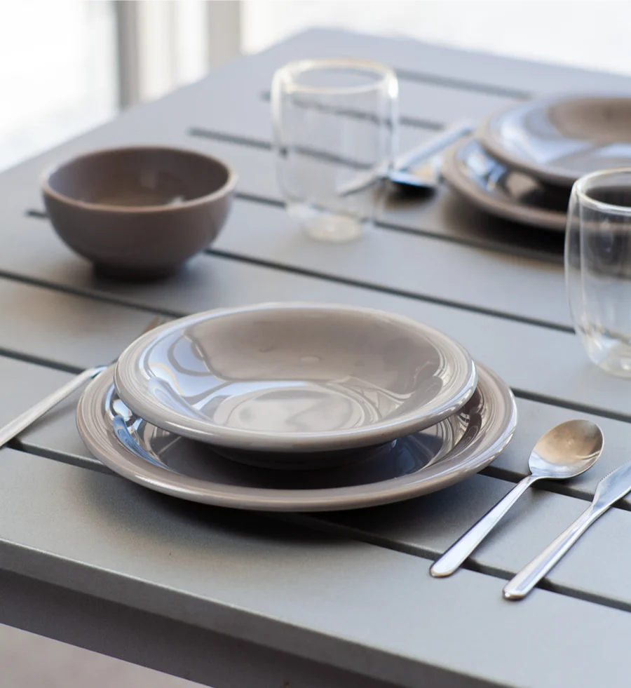 Mesa puesta con platos y bowl de cerámica color gris fumée